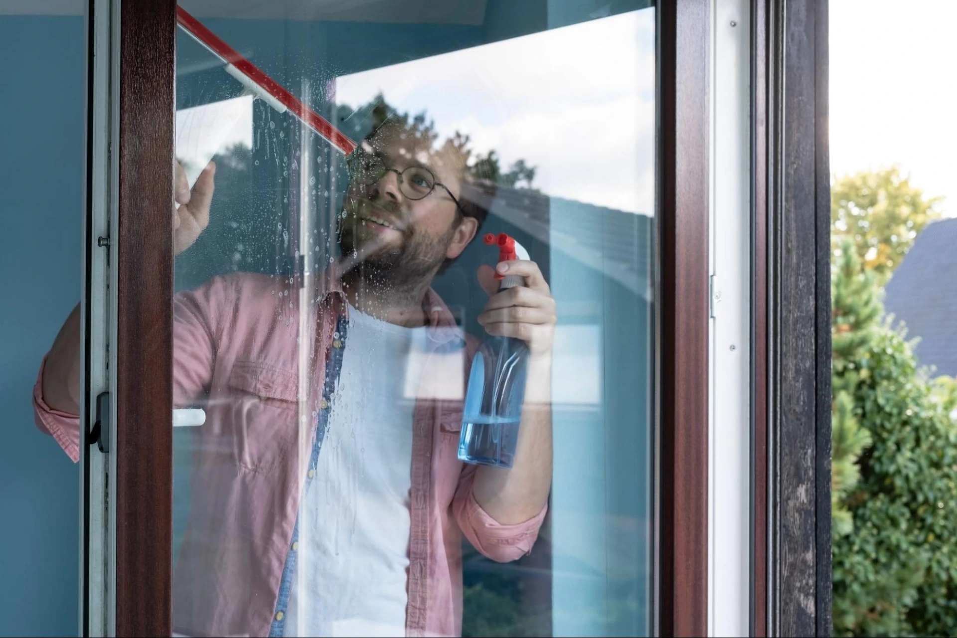 mężczyzna myjący okno w przygotowaniu na oklejenie folią