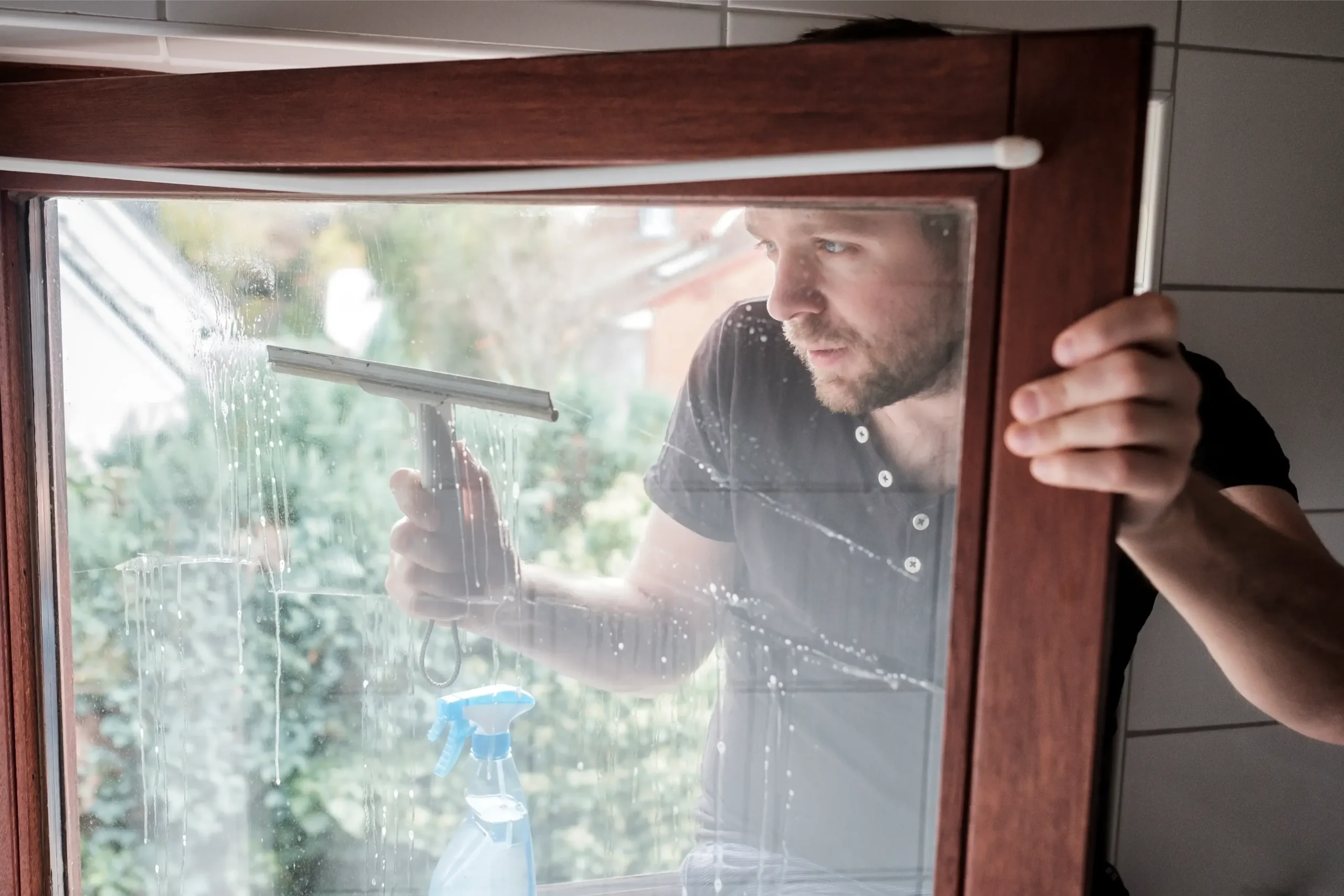 mężczyzna myjący okno